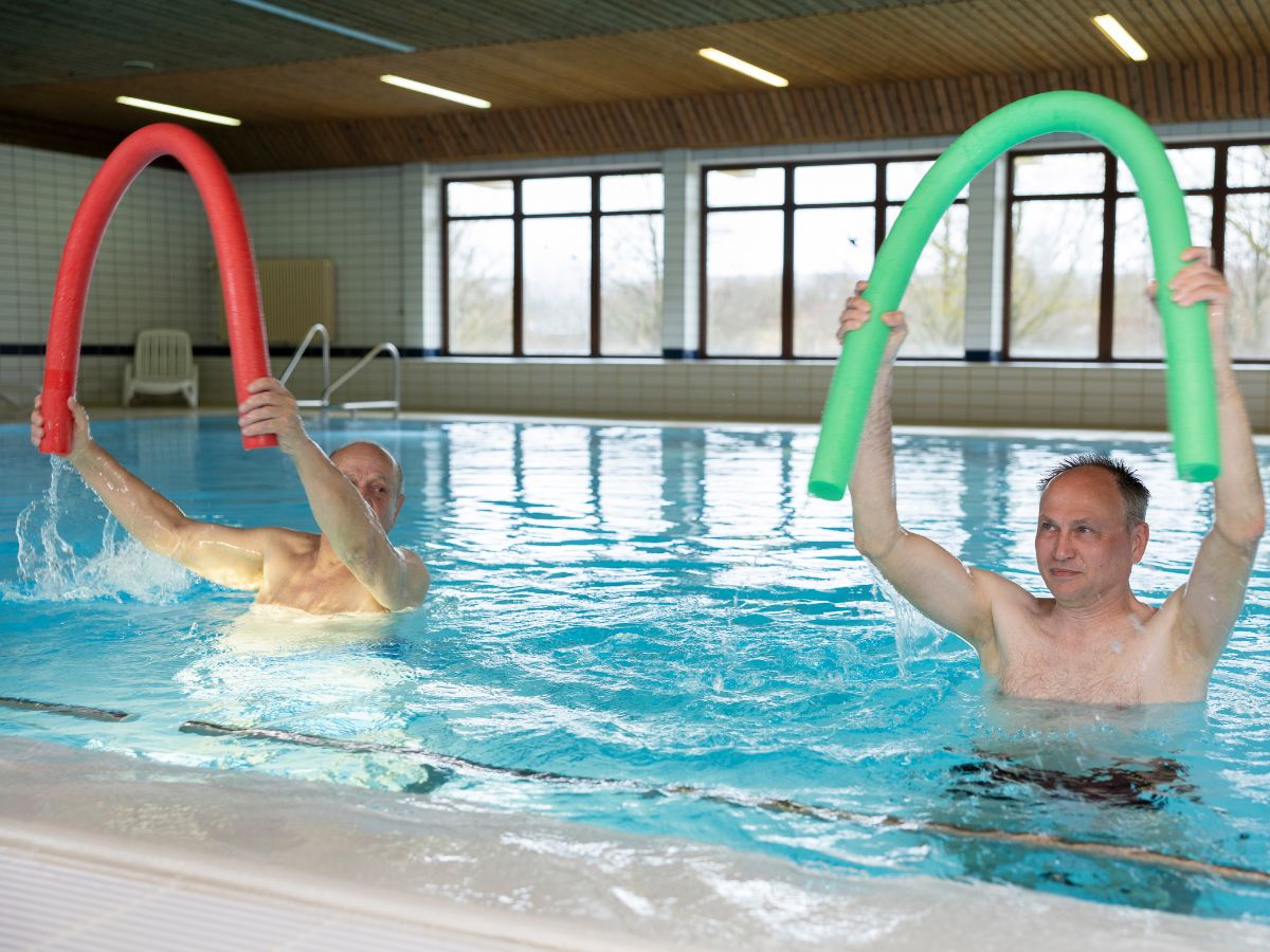 Zwei Männer bewegen sich im Schwimmbad