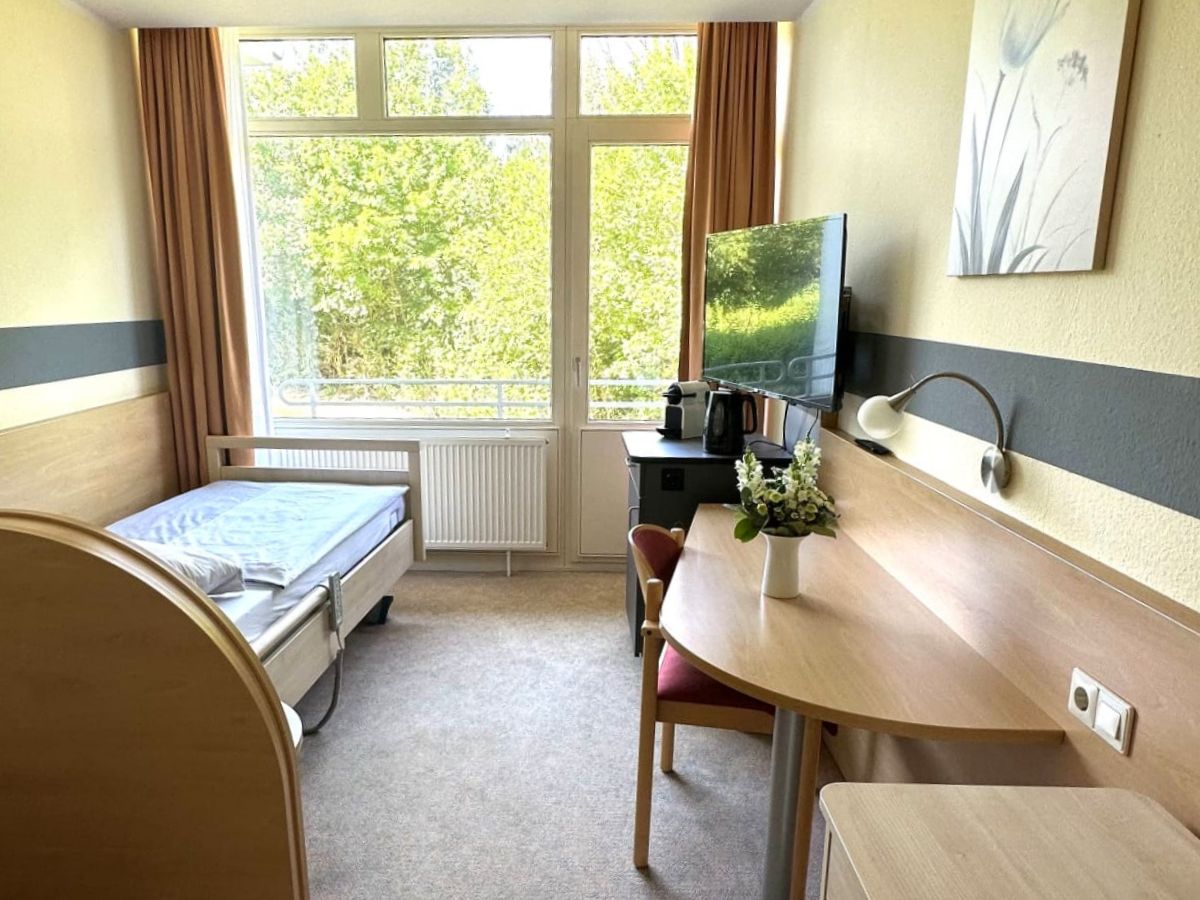 Select Living Einzelzimmer mit Balkon und Zusatzservices wie Kühlschrank und Kaffeemaschine.