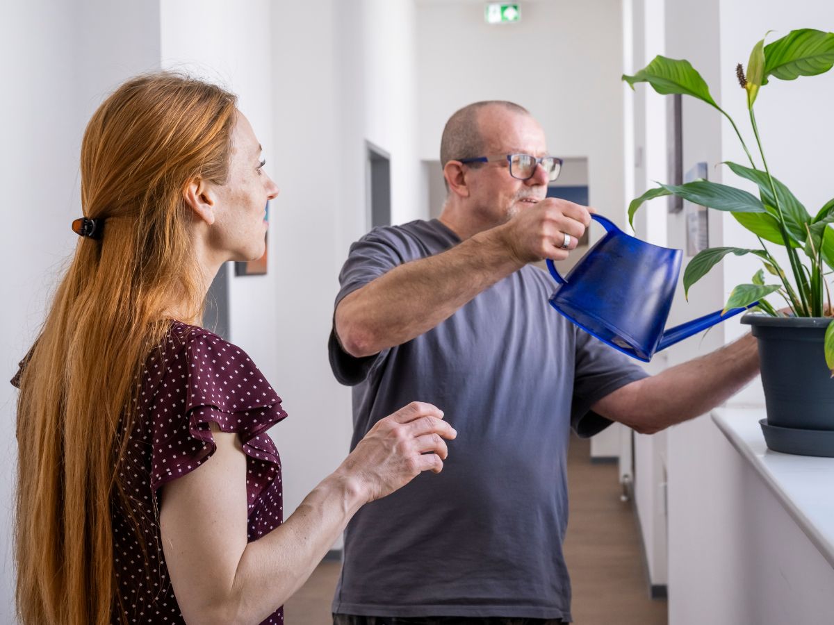 Ein Mann gießt die Blumen und die Frau steht daneben