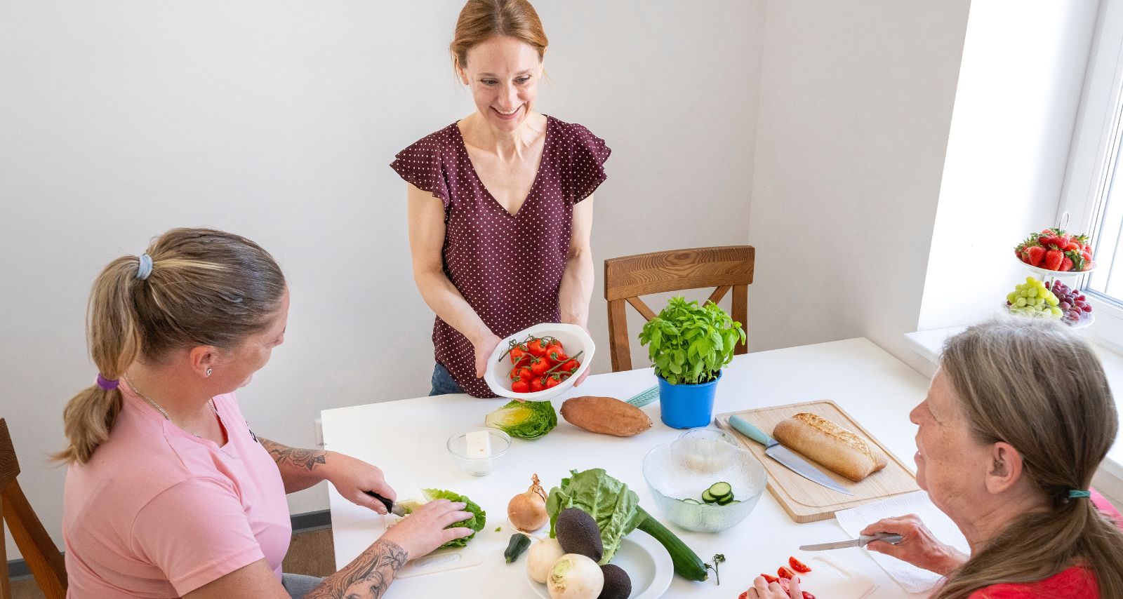 Eine Frau zeigt den anderen Frauen das Essen auf dem Tisch