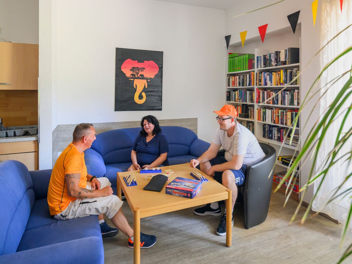 Drei Personen sitzen und reden im Aufenthalt