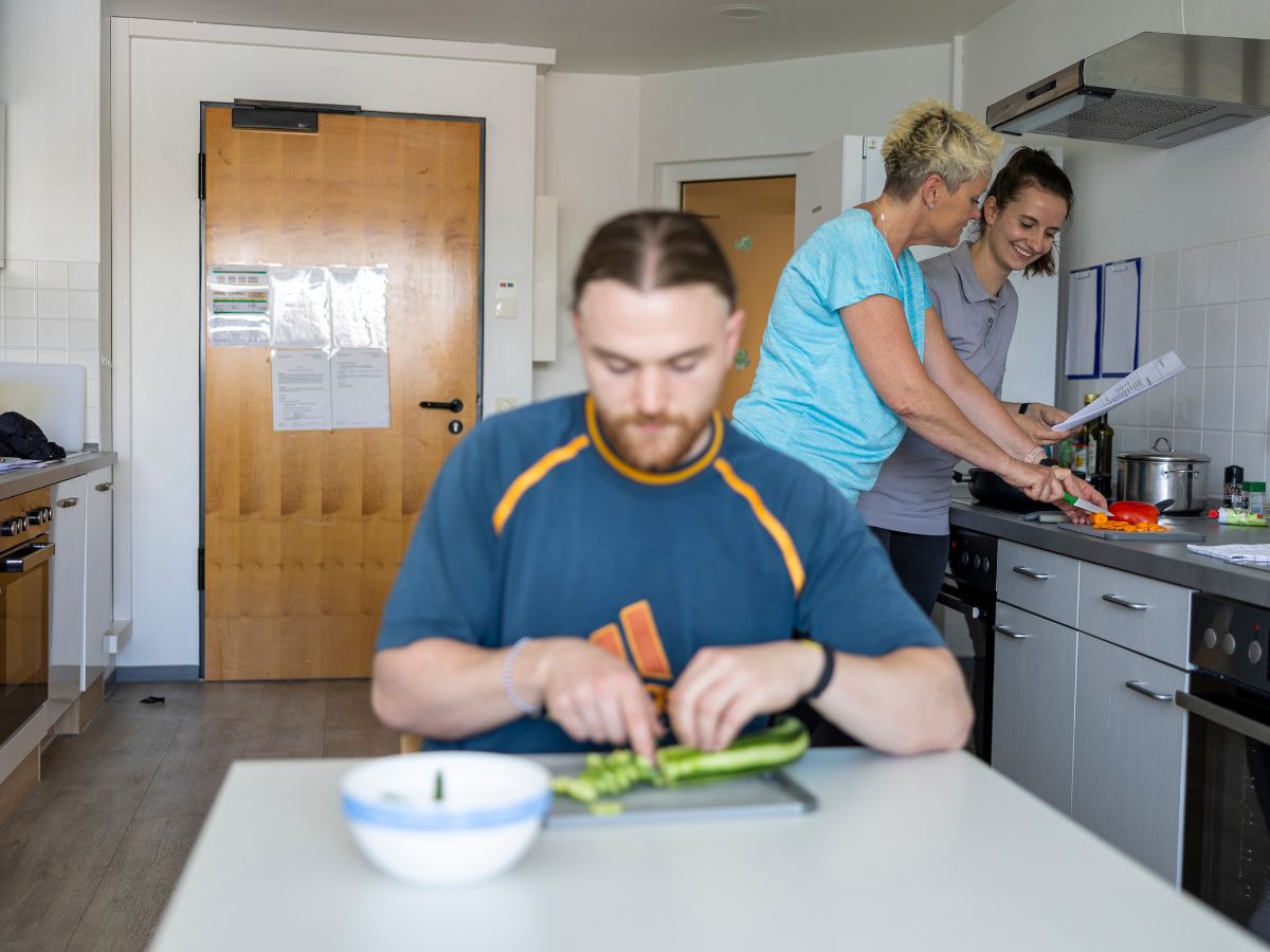 Personen die zusammen Gemüse schneiden 