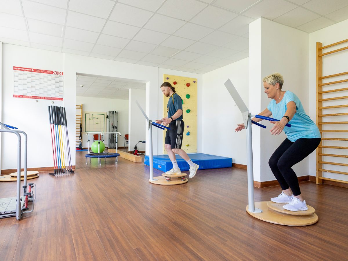 Zwei Personen die an einem Gerät Sport durchführen 