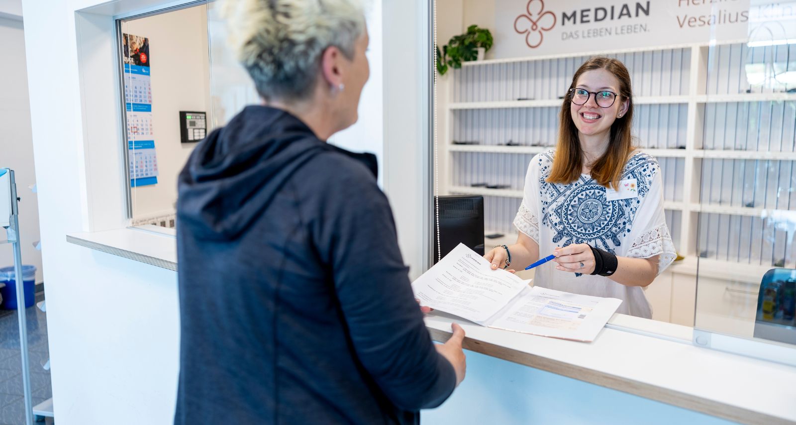 Eine Person die sich an der Rezeption anmeldet 