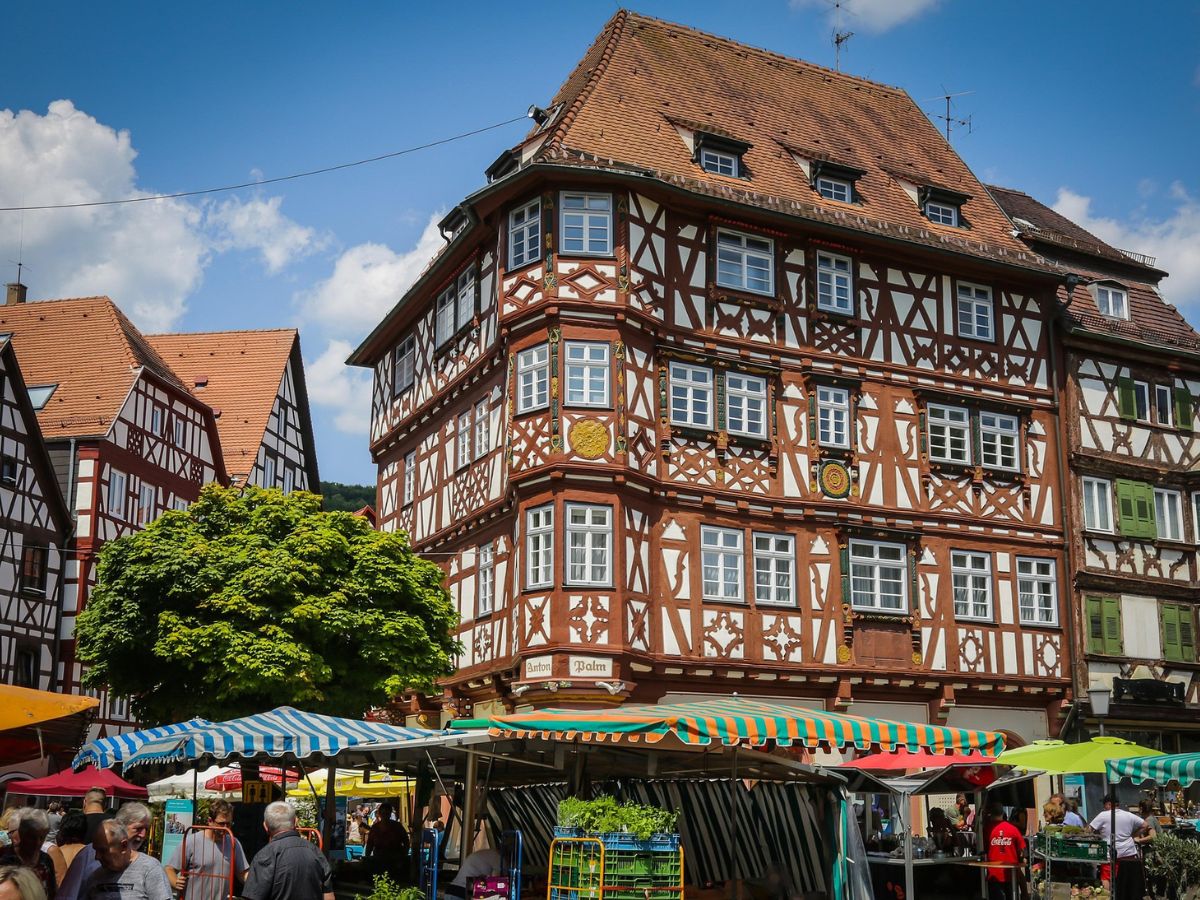 Großes Fachwerkhaus am Mosbacher Marktplatz mit Marktständen und Besucherinnen und Besuchern davor