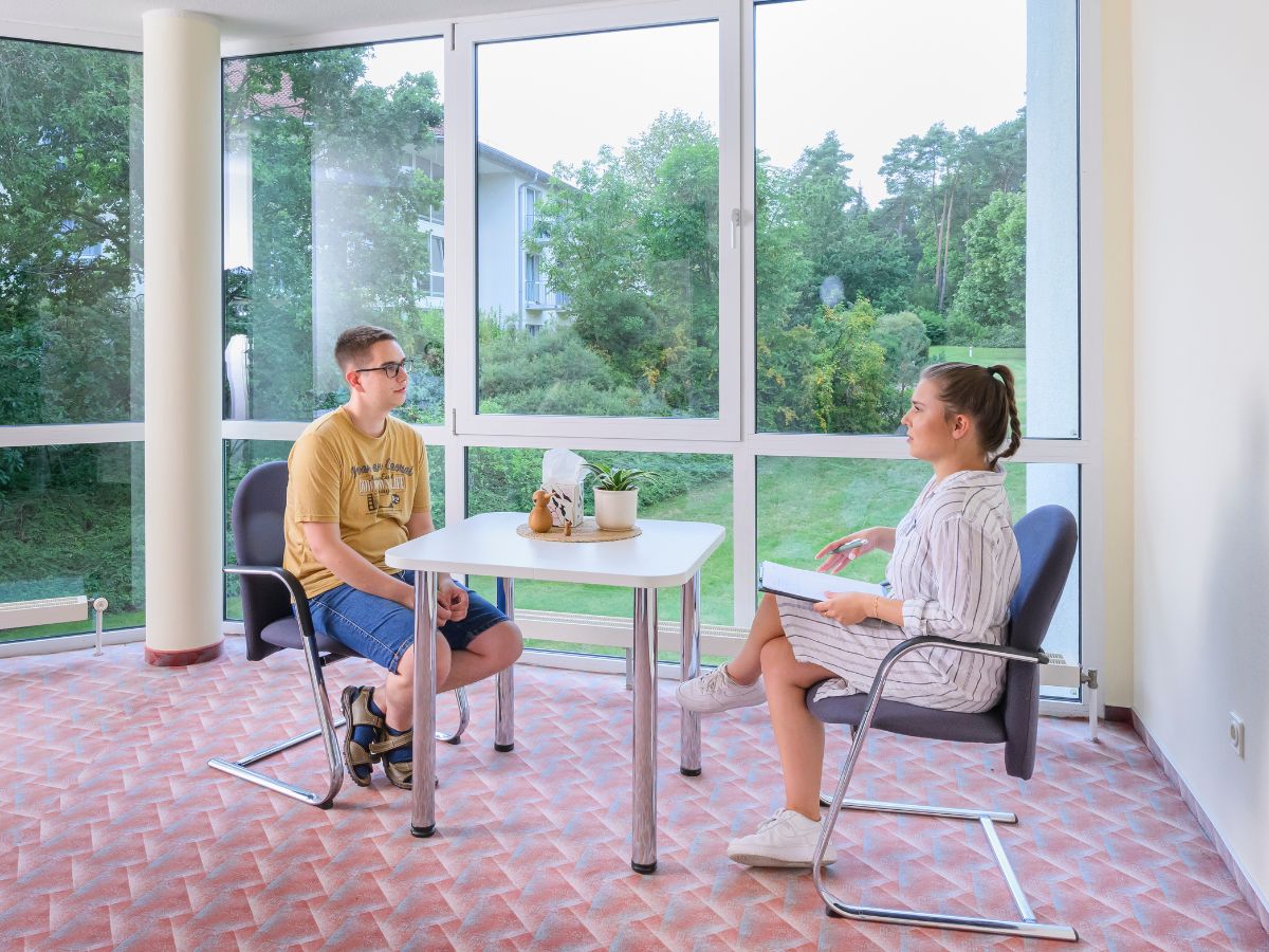 Zwei Personen sitzen am Tisch und unterhalten sich
