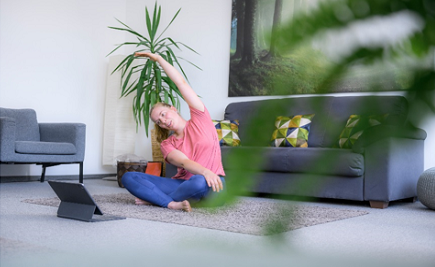 Person vorm Laptop macht Streching-Übungen